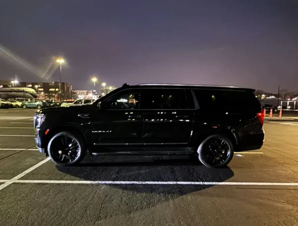 Black GMC Yukon XL, side view at night