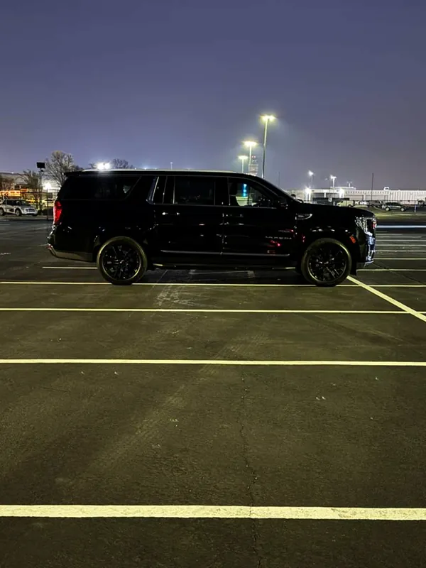 Black GMC Yukon XL in a parking lot at night
