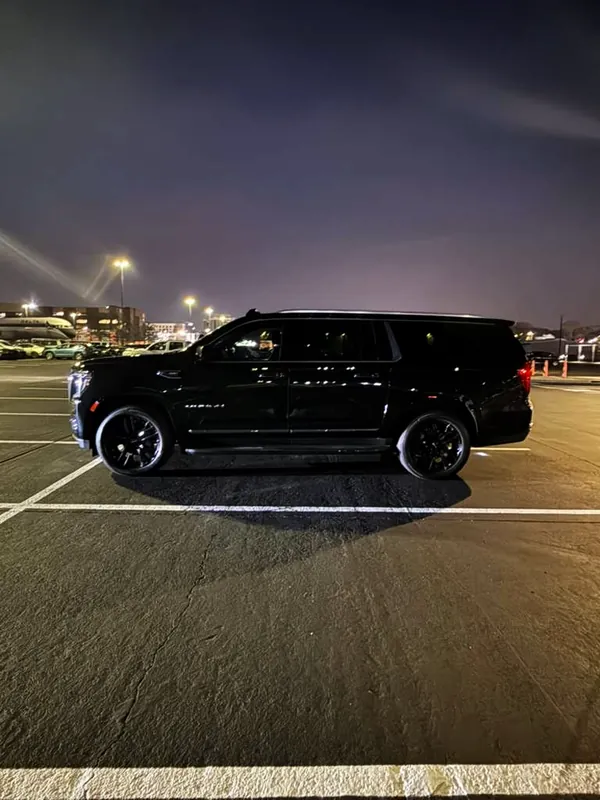 Black GMC Yukon XL under parking-lot lights