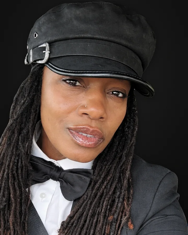 A Royalty Black Limousine chauffeur in a cap, bow tie and grey suit