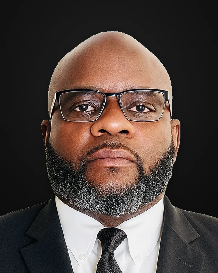 A Royalty Black Limousine chauffeur with glasses, in a black suit and tie